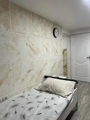 a bedroom with a bed with a clock on the wall at Apartmani Stevanovic in Despotovac