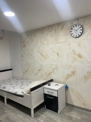 a room with a bed and a clock on a wall at Apartmani Stevanovic in Despotovac
