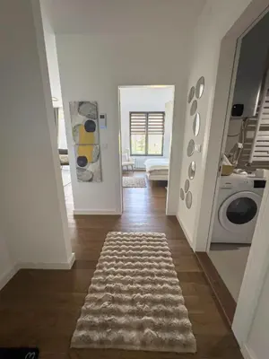 a hallway with a laundry room with a washing machine at Elegant Escape Lux, Planet Residence i Spa center in Niš