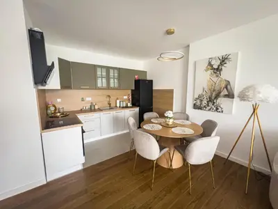 a kitchen with a table and chairs in a room at Elegant Escape Lux, Planet Residence i Spa center in Niš