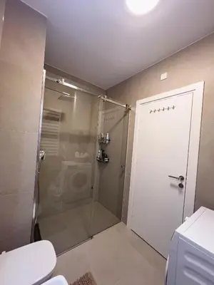 a bathroom with a shower and a glass door at Elegant Escape Lux, Planet Residence i Spa center in Niš