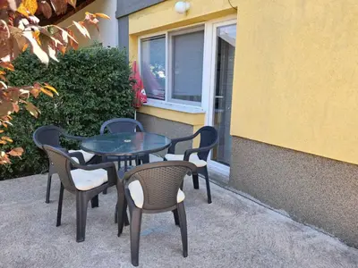 a table and chairs sitting next to a building at Apartmani Vila Pola in Soko Banja