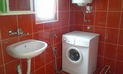 a bathroom with a washing machine and a sink at Apartmani Vila Pola in Soko Banja