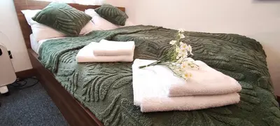 a bed with towels and pillows on it at Daisy Apart SKI OUT SKI IN Vila Bela Reka Brzece in Brzeće