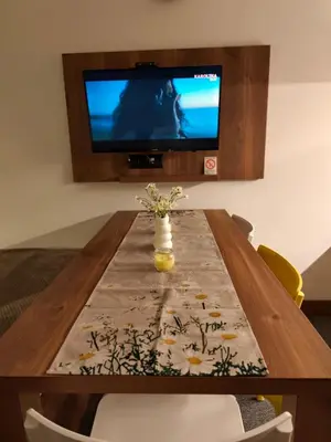 a wooden table with a vase of flowers on it at Daisy Apart SKI OUT SKI IN Vila Bela Reka Brzece in Brzeće