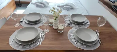 a table with plates and wine glasses on a bed at Daisy Apart SKI OUT SKI IN Vila Bela Reka Brzece in Brzeće