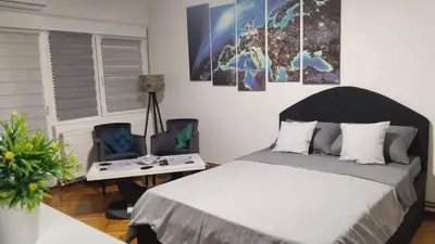 a bedroom with a bed and a table and a chair at Lela's home II in Knjazevac.