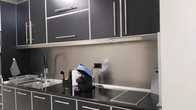 a kitchen with black cabinets and a sink at Lela's home II in Knjazevac.