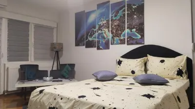 a bedroom with a bed with four paintings on the wall at Lela's home II in Knjazevac.