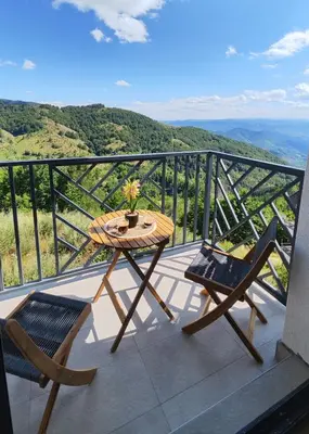 a table and chairs on a balcony with a view at SKY VIEW Apartment - Ski resort Kopaonik in Cajetina