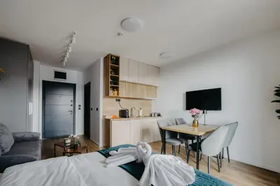 a bedroom with a bed and a table and a kitchen at SKY VIEW Apartment - Ski resort Kopaonik in Cajetina
