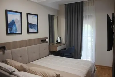 a bedroom with a bed and a desk and a mirror at Apartment Ornament Lux B11 in Vrnjačka Banja