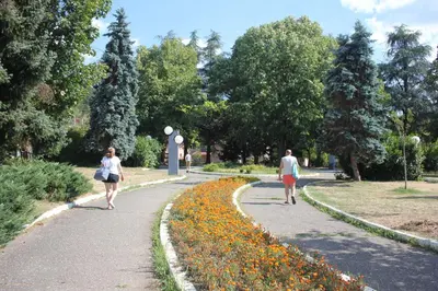 two people walking down a path in a park at Apartment Ornament Lux B11 in Vrnjačka Banja