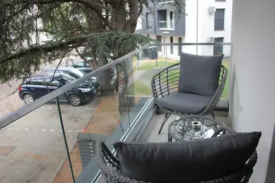 a balcony with a chair and a table at Apartment Ornament Lux B11 in Vrnjačka Banja