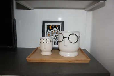 two white vases with glasses sitting on a shelf at Apartment Ornament Lux B11 in Vrnjačka Banja