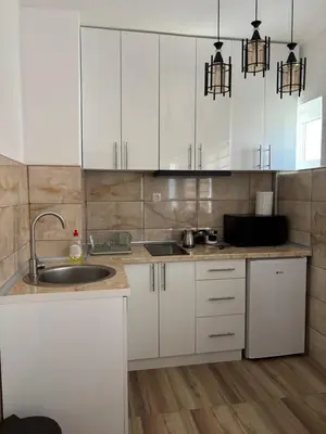 a kitchen with white cabinets and a sink at Apartman A2 in Vrnjačka Banja