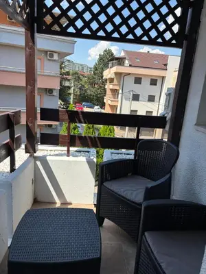 a balcony with two chairs and a view of a building at Apartman A2 in Vrnjačka Banja