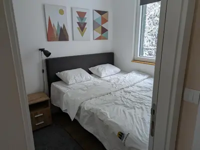 a bedroom with a bed with white sheets and a window at Silverpine, Kopaonik in Kopaonik