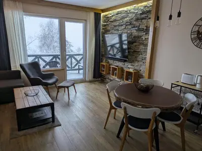 a living room with a table and chairs and a tv at Silverpine, Kopaonik in Kopaonik