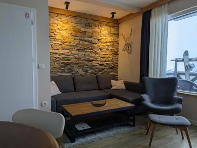 a living room with a couch and a brick wall at Silverpine, Kopaonik in Kopaonik