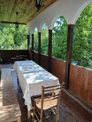 a bedroom with a bed and a chair on a porch at KAMENICA Stara Planina in Dimitrovgrad