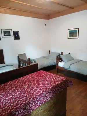 a living room with three beds and a red rug at KAMENICA Stara Planina in Dimitrovgrad