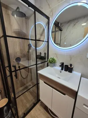 a bathroom with a shower and a sink and a mirror at Skyline Panorama in Vrnjačka Banja