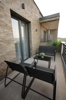 a patio with two chairs and a table at Skyline Panorama in Vrnjačka Banja