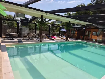 an outdoor swimming pool with a pergola over it at Skyline Panorama in Vrnjačka Banja