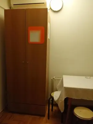 a cabinet with an orange box next to a table at Pansion Velickovic in Niška Banja