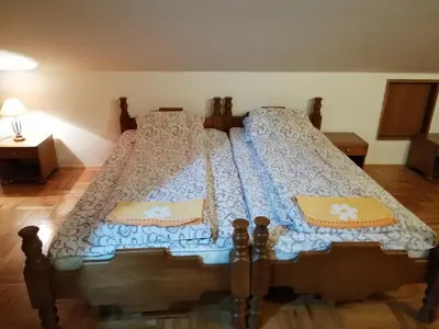 a bedroom with a bed with a blue and white comforter at Pansion Velickovic in Niška Banja