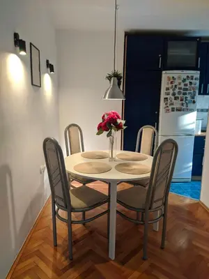 a dining room table and chairs with a vase of flowers on it at Golden lady in Niš