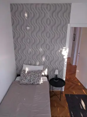 a bedroom with a bed and a wall with a pattern at Golden lady in Niš