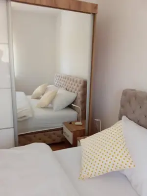a mirror reflection of a bedroom with a bed at Apartmani Vrnjacka Banja in Vrnjci