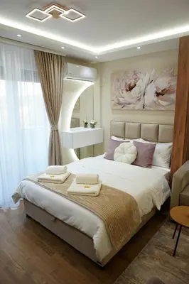 a bedroom with a large bed with a painting on the wall at Apartman NIKOLINA in Vrnjačka Banja
