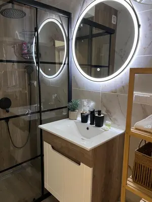 a bathroom with a sink and a shower with a mirror at Apartman NIKOLINA in Vrnjačka Banja