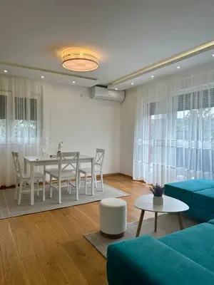 a living room with a table and a blue couch at VIP House 4 in Vrnjačka Banja