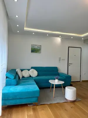 a living room with a blue couch and a table at VIP House 4 in Vrnjačka Banja