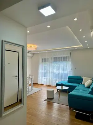 a living room with a blue couch and a mirror at VIP House 4 in Vrnjačka Banja