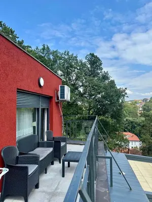 a balcony with chairs and a red building at VIP House 4 in Vrnjačka Banja