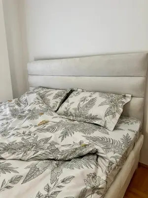 a bed with a blanket and two pillows on it at Vidolux Studio - Free Garage and Fast WiFi in Niš