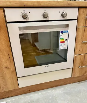 a white oven in a kitchen with wooden cabinets at Vidolux Studio - Free Garage and Fast WiFi in Niš