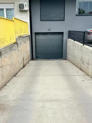 a garage with a blue garage door on a building at Vidolux Studio - Free Garage and Fast WiFi in Niš