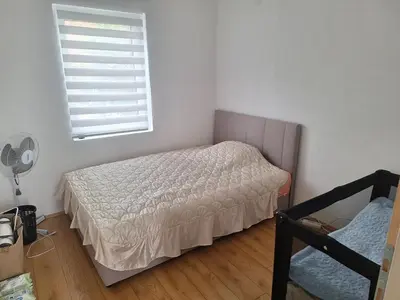 a small bedroom with a bed and a window at Tomić