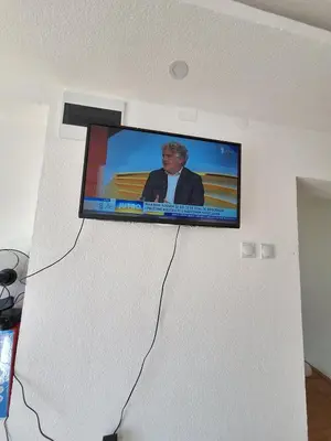 a flat screen tv hanging on a wall at Tomić