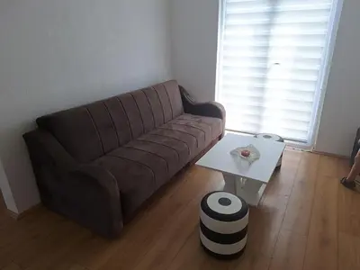 a brown couch in a living room with a table at Tomić