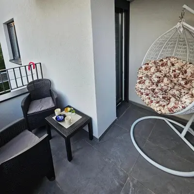 a living room with a large pizza in a swing at Apartmani Giga in Vrnjci