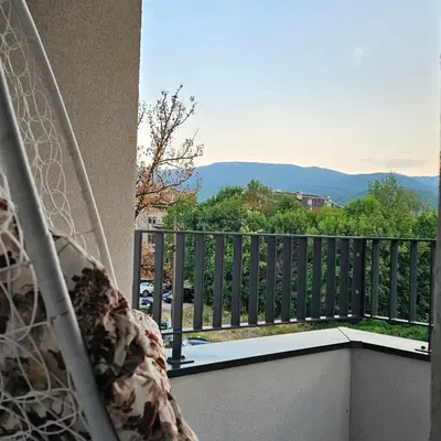 a bed on a balcony with a view of the mountains at Apartmani Giga in Vrnjci