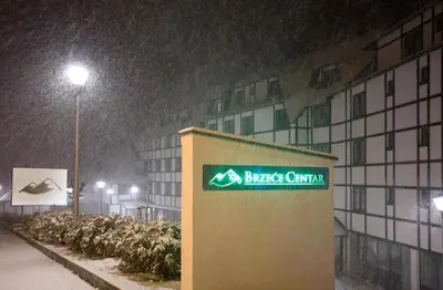 a building with a sign on it in the snow at Apartman Aleksandar AS in Brzeće