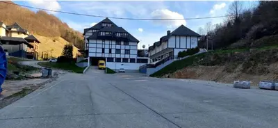 an empty street with two large buildings on a hill at Apartman Aleksandar AS in Brzeće